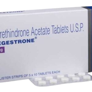 A close-up shot of a white medication box and a blister strip. The box displays the text "Norethindrone Acetate Tablets U.S.P." in blue lettering, with the brand name "REGESTRONE" printed below it. A purple square on the left indicates the dosage (partially visible). At the bottom of the box, it mentions "BLISTER STRIPS OF 5 x 10 TABLETS EACH." In the foreground, a silver blister strip is partially visible, showing several small, round, white tablets.