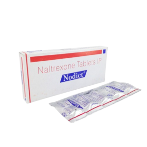A product box and blister pack for Nodict, which contains Naltrexone Tablets IP. The box is white with red and blue accents, featuring the brand name in a blue banner. In the foreground, a silver foil blister strip is visible, showing the individual compartments for the tablets. The packaging identifies the manufacturer with a small logo on the side of the box.